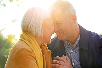 Senior couple holding hands and smiling in warm sunlight