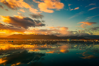 Dramatic sunset over Jökulsárlón glacier lagoon with icebergs and reflections