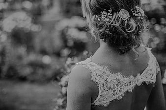 Black and white back view of bride with lace dress and flowers