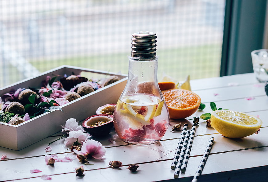 Infused water in lightbulb bottle with fruits and flowers