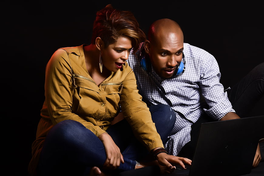 Surprised couple reacting to content on a laptop screen