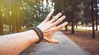 Man's Hand with Wooden Bracelet in Sunlit Forest