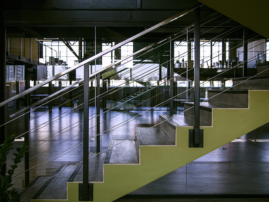 Modern industrial staircase with steel cables and green risers
