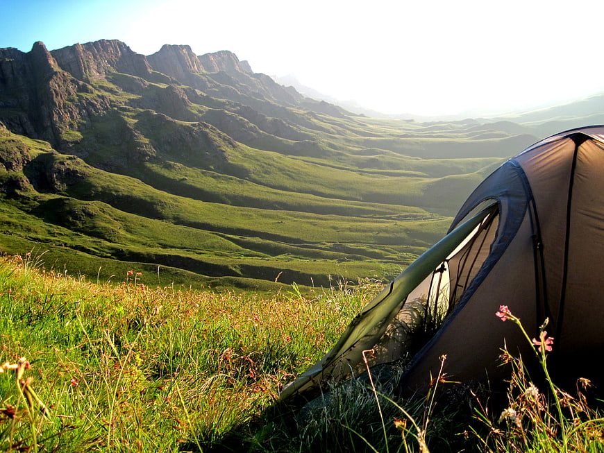 Camping Tent On Grassy Mountain Ridge With Distant Peaks