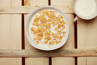 Top View of Corn Flakes Cereal Bowl with Milk on Wooden Table
