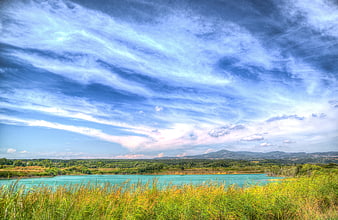 Vibrant HDR landscape of a turquoise lake in Tuscany