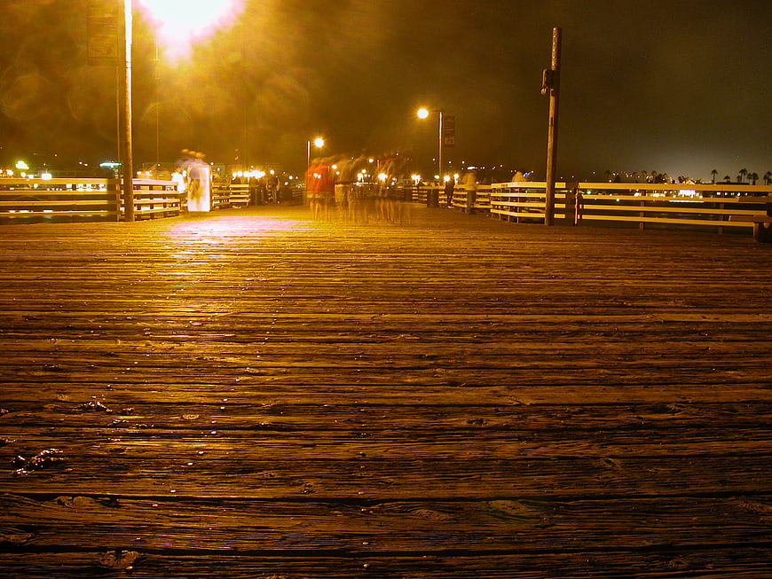 Night view of wooden pier with motion blur and streetlights