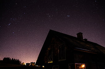 Silhouette of a house under a starry night sky