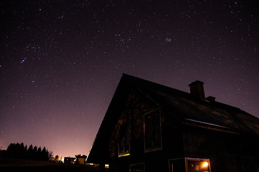 Silhouette of a house under a starry night sky
