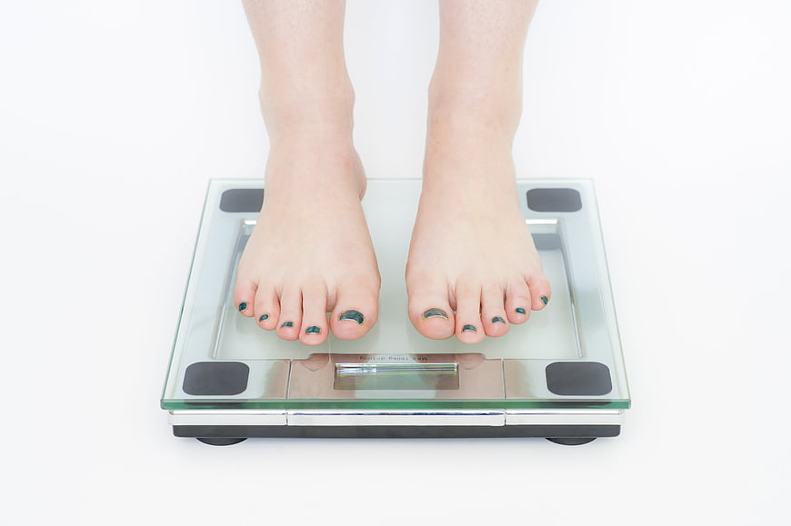 Bare feet standing on a digital bathroom scale