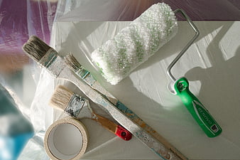 Painting tools and renovation supplies on protective sheet