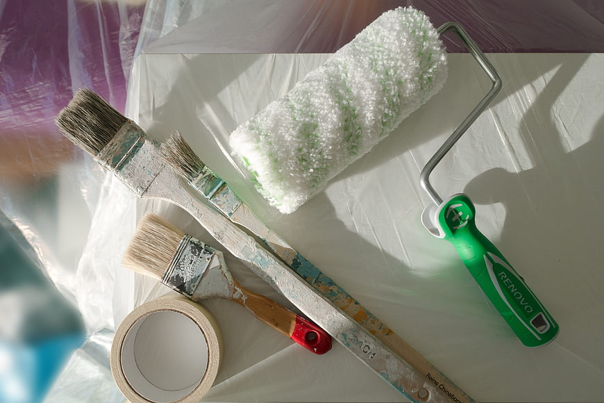 Painting tools and renovation supplies on protective sheet