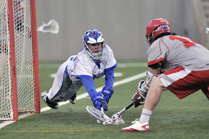 Lacrosse Goalie Diving to Block Shot on Field