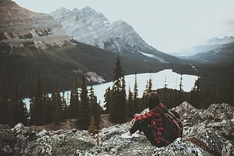 Woman Hiker Sitting on Rocky Mountain Overlooking Lake