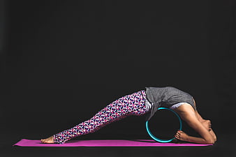 Woman doing yoga wheel backbend on pink mat