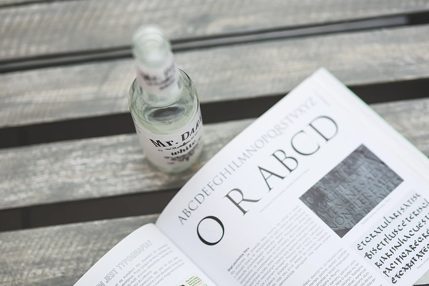 Typography book and clear bottle on wooden table