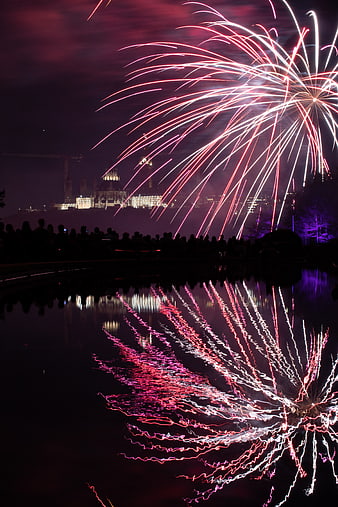 Vibrant Fireworks Display Reflected in Water at Night