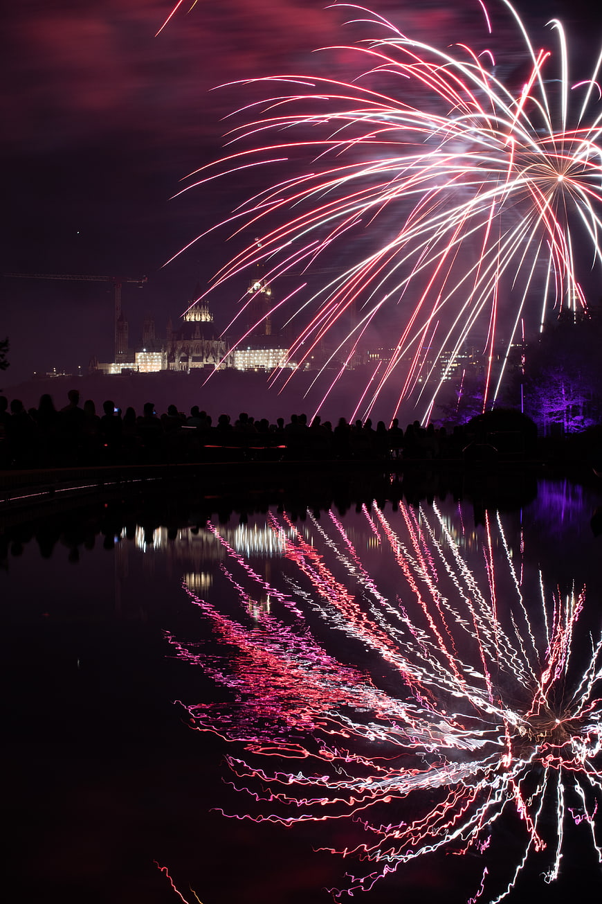 Vibrant Fireworks Display Reflected in Water at Night