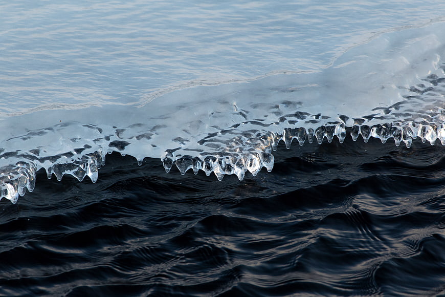 Frozen Ice Edge on Dark Water Surface
