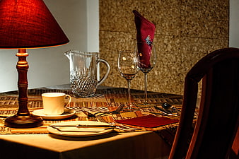 Elegant dinner table setting with lamp and wine glasses
