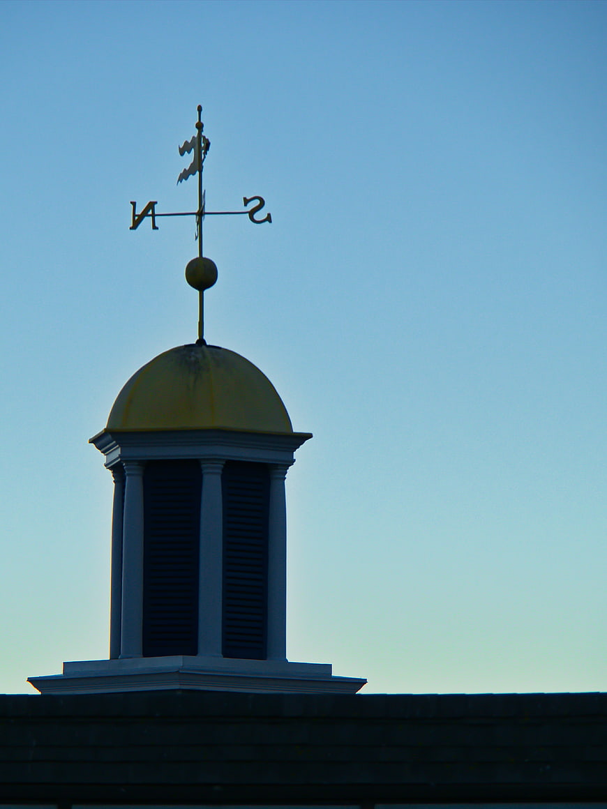 Golden Cupola with Weather Vane Against Blue Sky