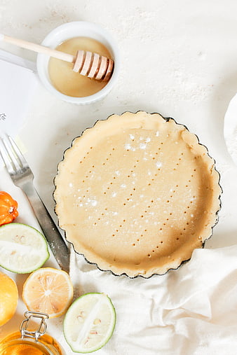 Top view of unbaked tart crust with honey and citrus