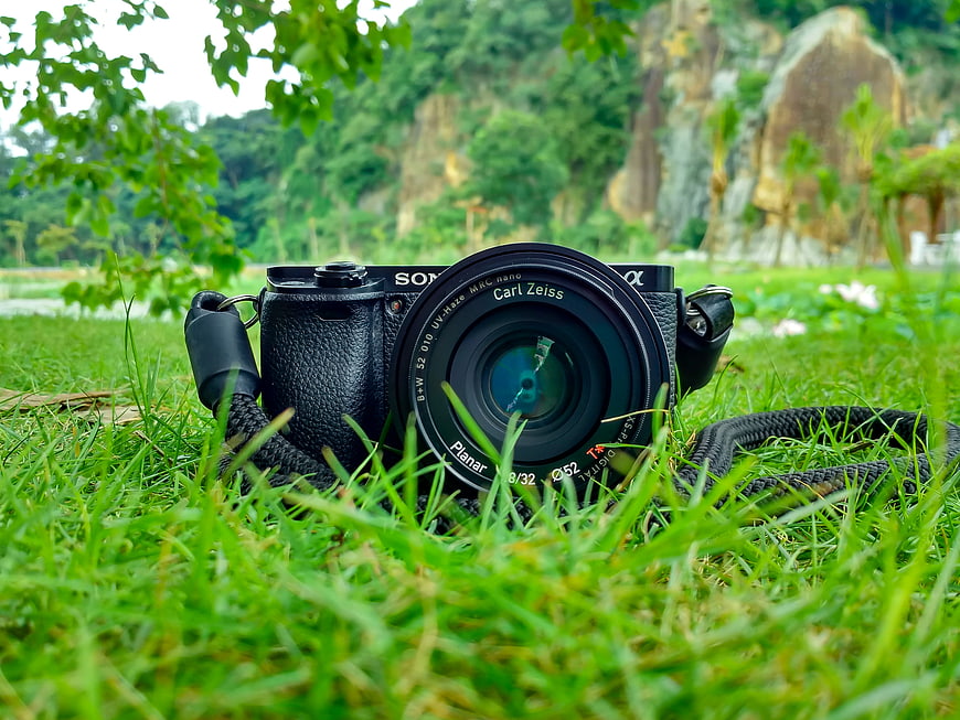 Black Sony Camera with Zeiss Lens on Green Grass