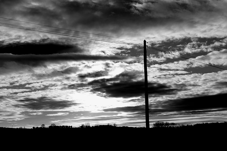 Dramatic black and white clouds over rural landscape silhouette