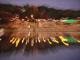 Abstract blurred city lights reflecting in water at dusk