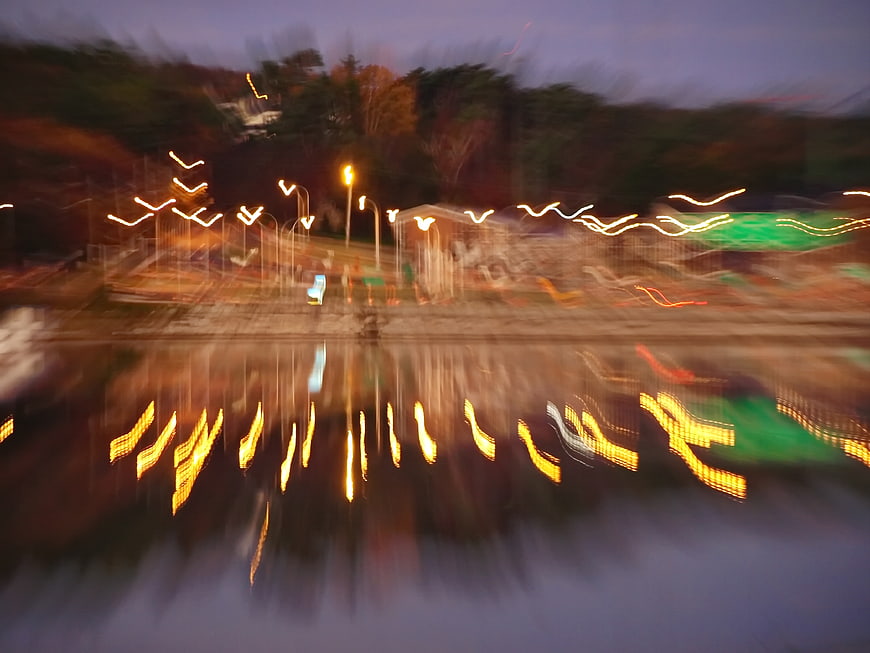 Abstract blurred city lights reflecting in water at dusk