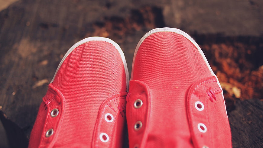 Close-up of red canvas sneakers on wooden surface