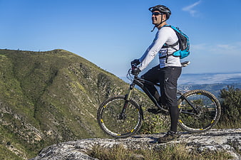 Mountain Biker Resting on Rocky Summit with Scenic View