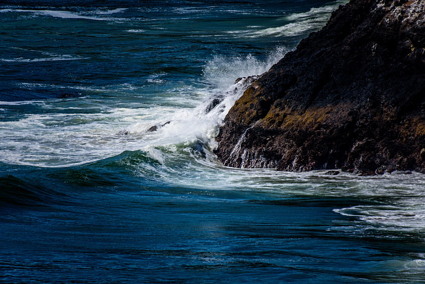 Powerful Ocean Waves Crashing Against Dark Rocky Coastline