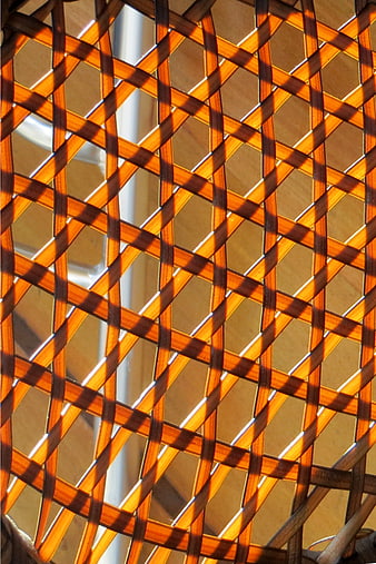 Close-up of woven rattan lattice pattern with sunlight