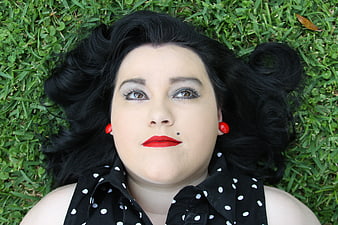 Retro Woman Lying on Grass with Red Lips and Polka Dot Shirt