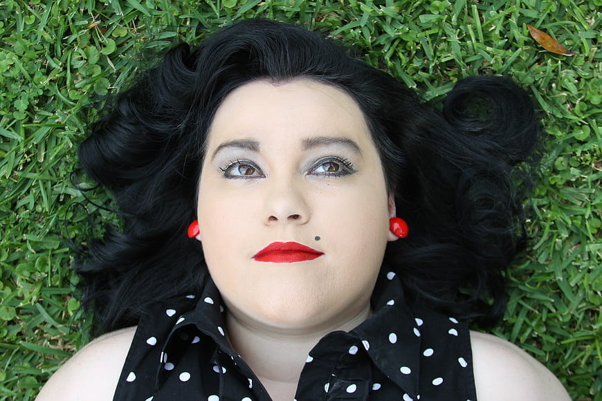Retro Woman Lying on Grass with Red Lips and Polka Dot Shirt