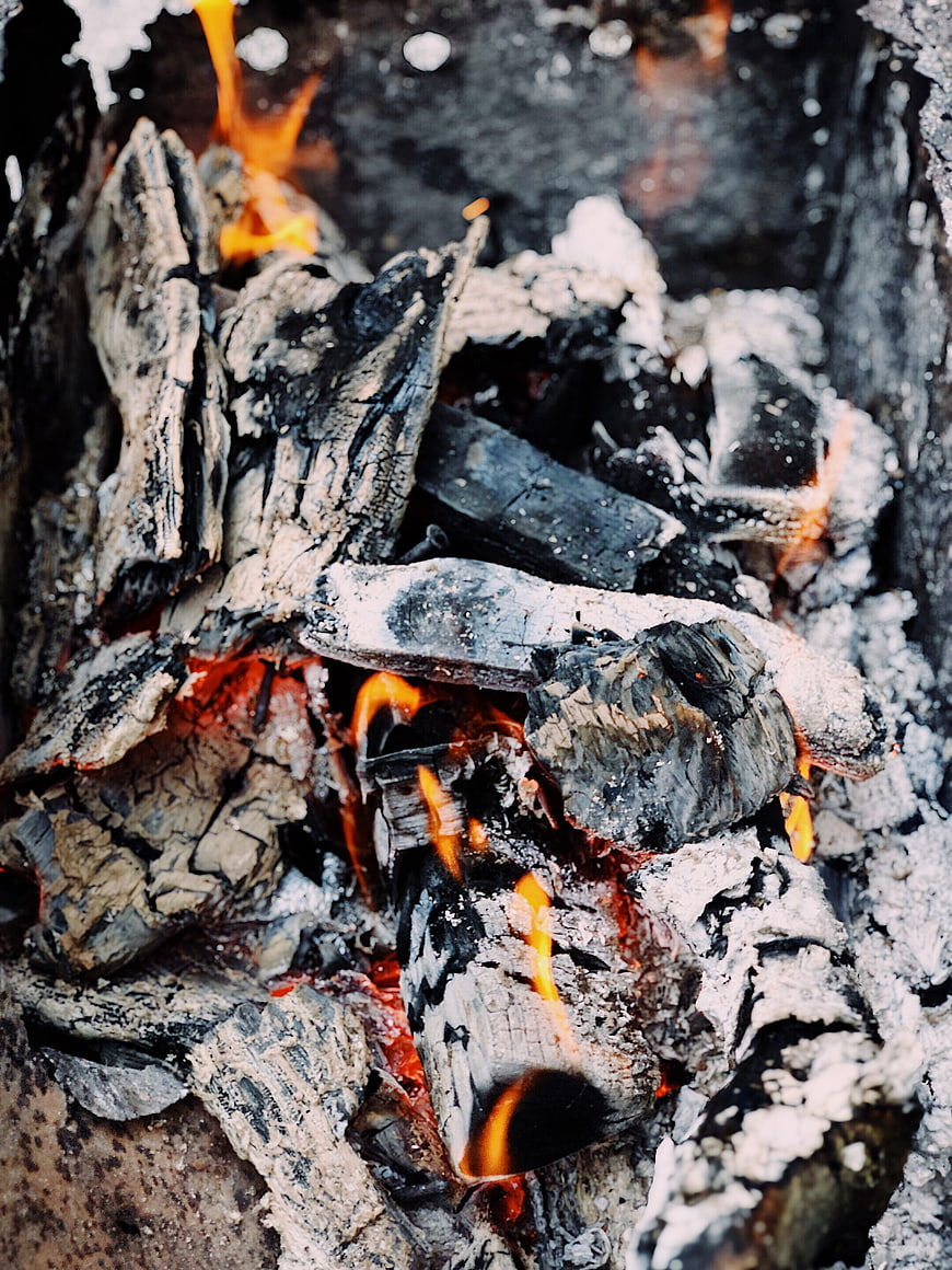 Close-up of burning charcoal and wood embers in a campfire