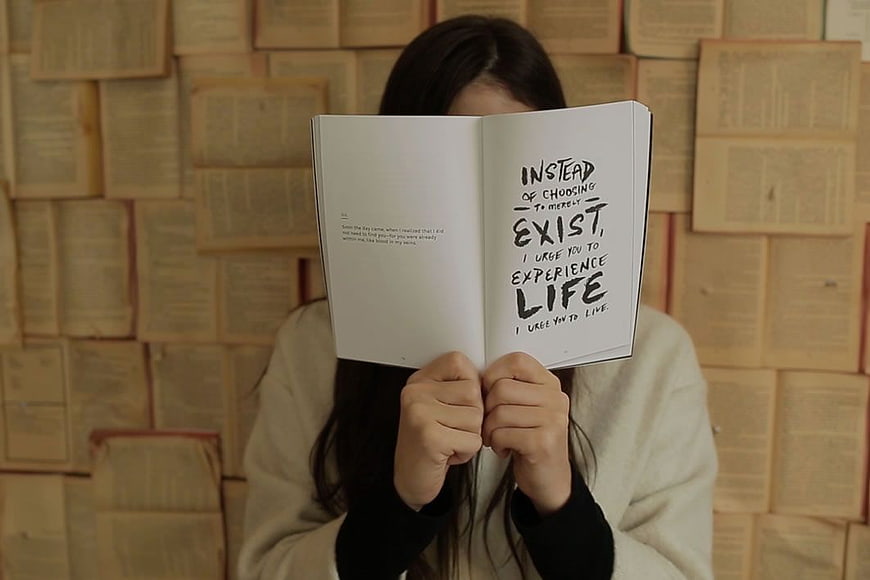Woman Reading Inspirational Quote in Book