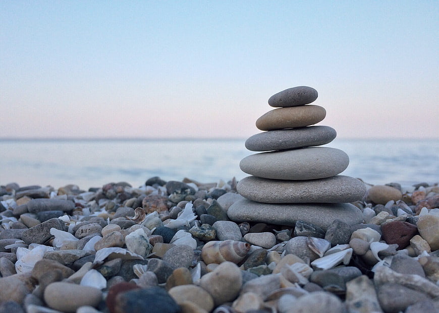 Stacked stones on pebble beach at sunset