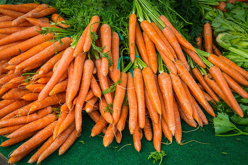 Fresh Organic Carrots With Green Tops On Market Display