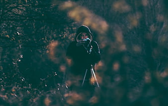Mysterious Hooded Photographer in Dark Forest