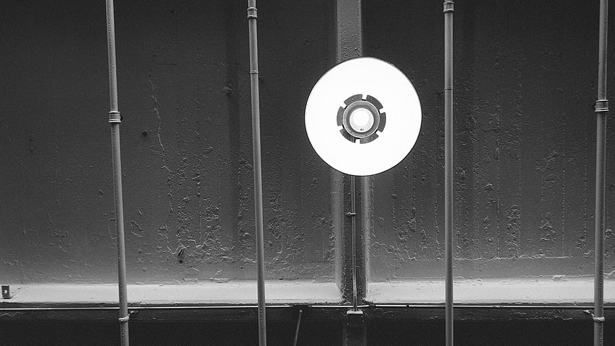 Black and white industrial light fixture on textured wall