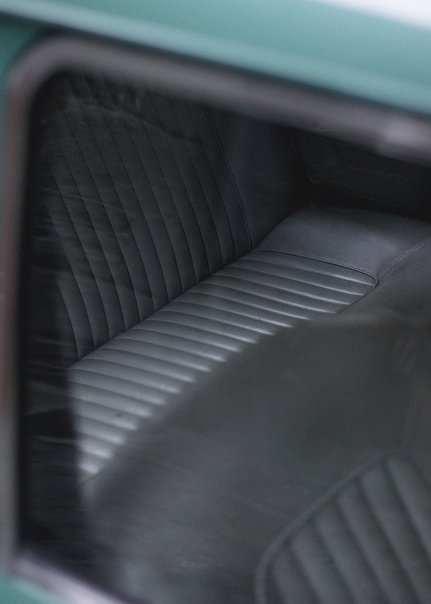 Close-up of vintage car interior with ribbed leather seats