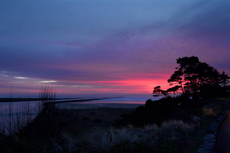 Dramatic Pink and Purple Sunset Over Coastal Beach Silhouette