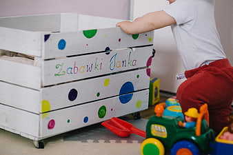 Toddler playing with toys near personalized wooden crate