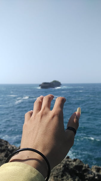 Hand Reaching Out to Ocean Island View