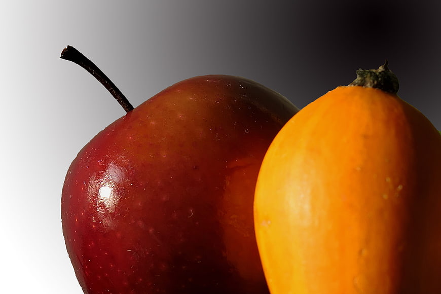 Close-up of Red Apple and Orange Pumpkin on Gradient Background