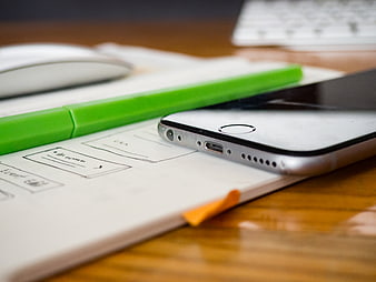 Smartphone and Sketchbook on Wooden Desk