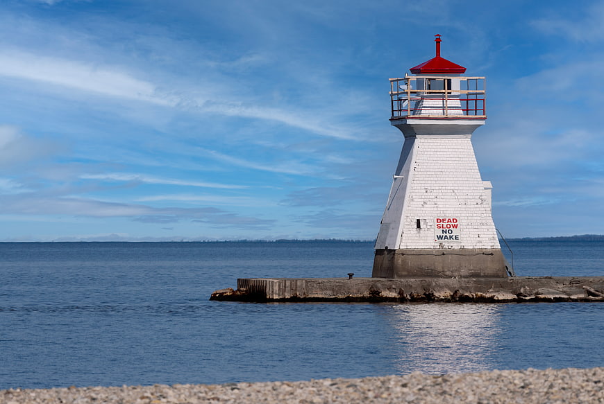 White Lighthouse with Red Roof on Concrete Pier