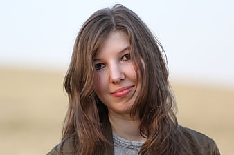 Portrait of young woman with brown hair outdoors